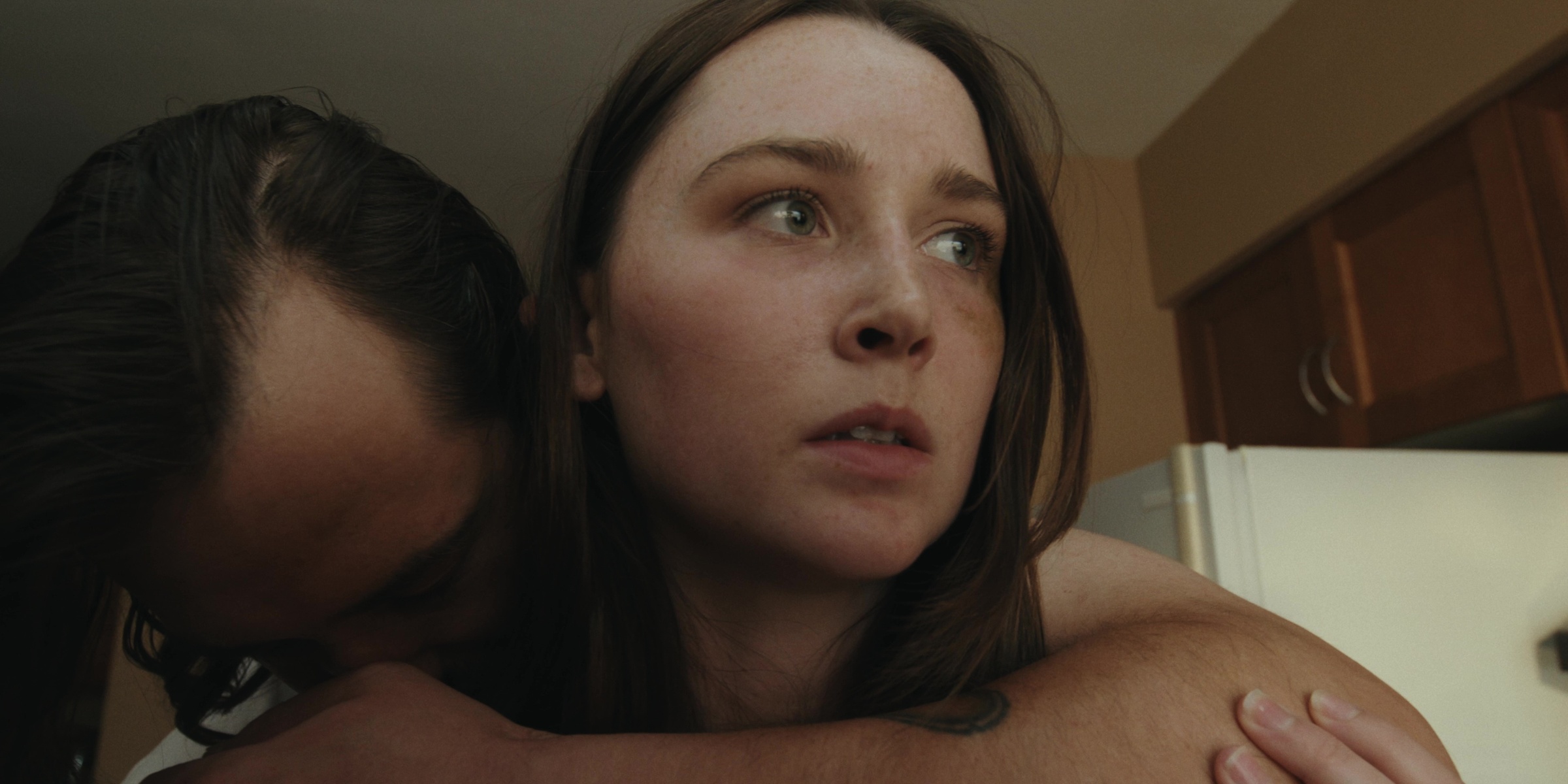 A woman looks away as a man embraces her from behind — Bottom of the bottle