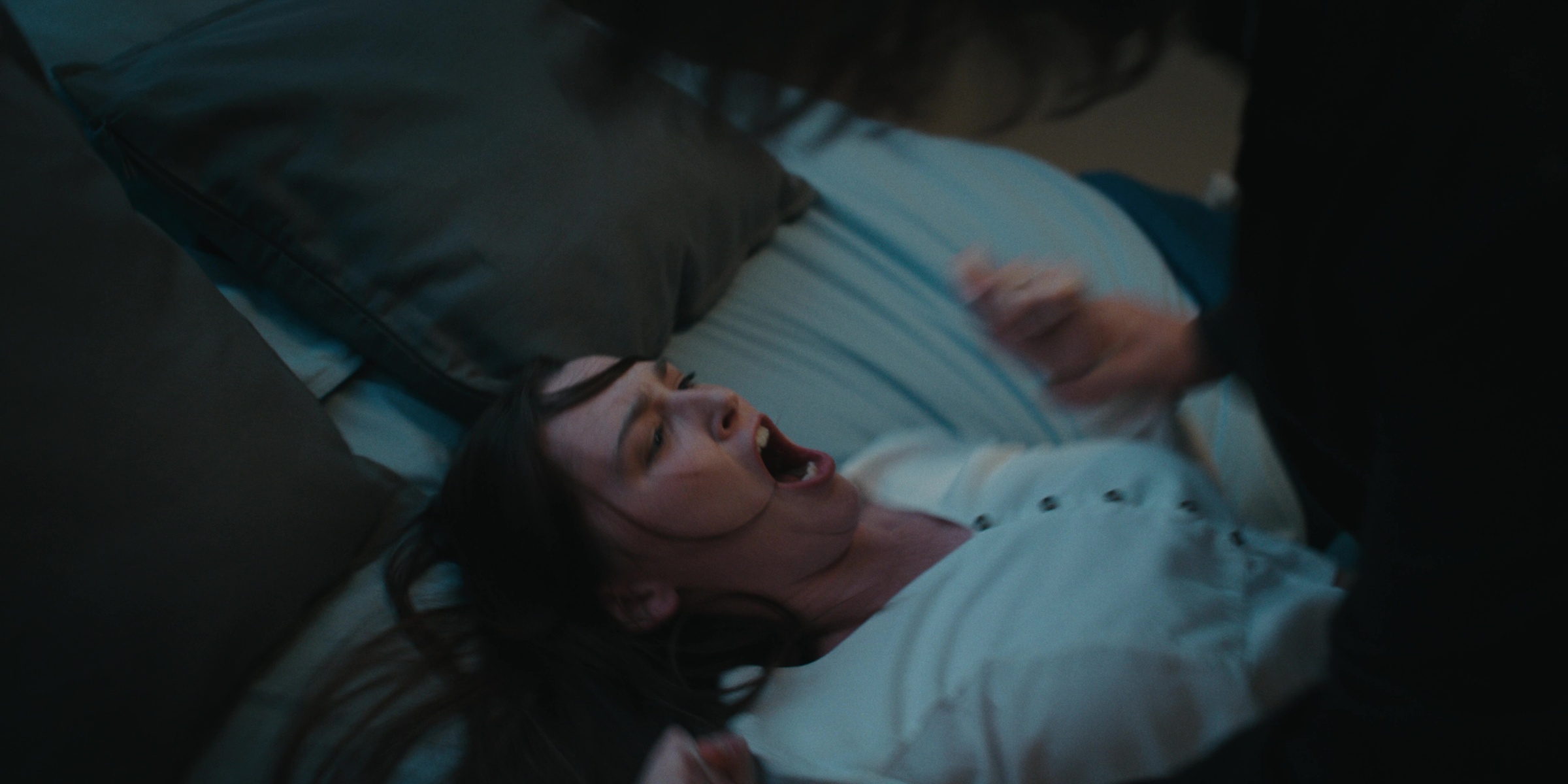 A woman lies on a bed with her mouth open — Bottom of the bottle