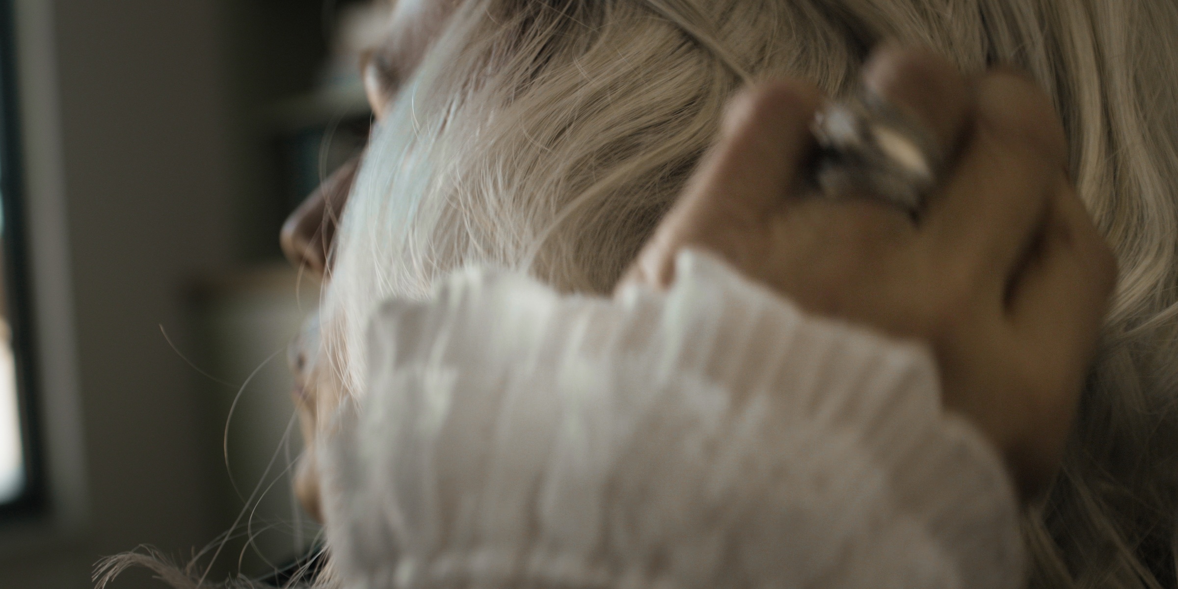 Close-up of a ringed hand touching blonde hair — Chiquel
