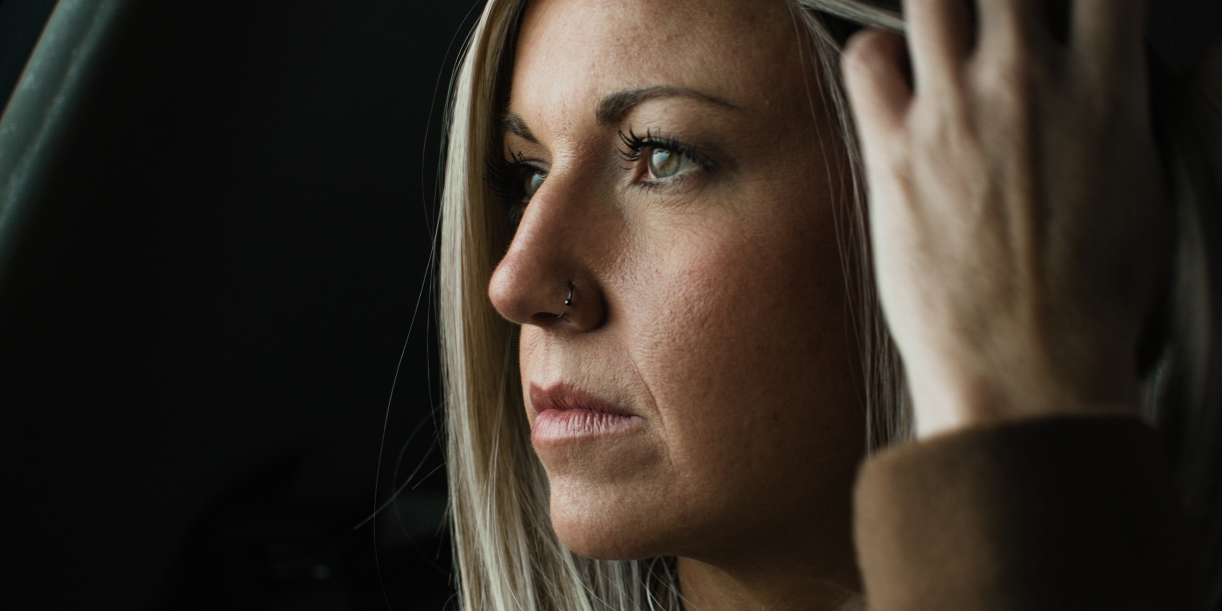 Close-up of a blonde woman looking out a car window — Chiquel