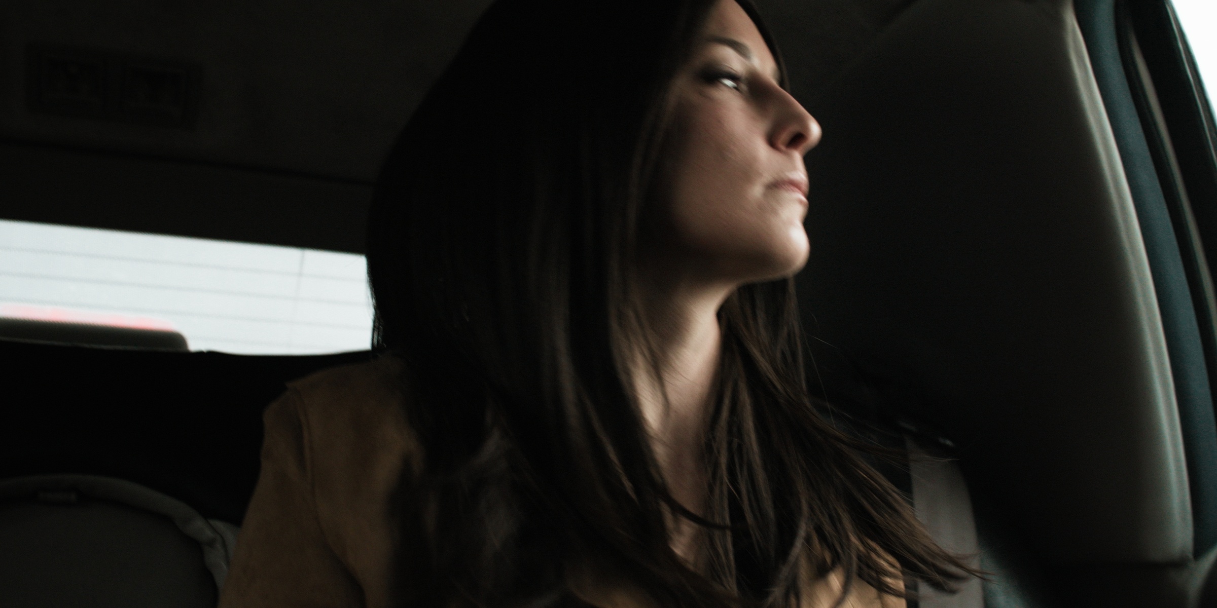 A brunette woman looks out a car window — Chiquel
