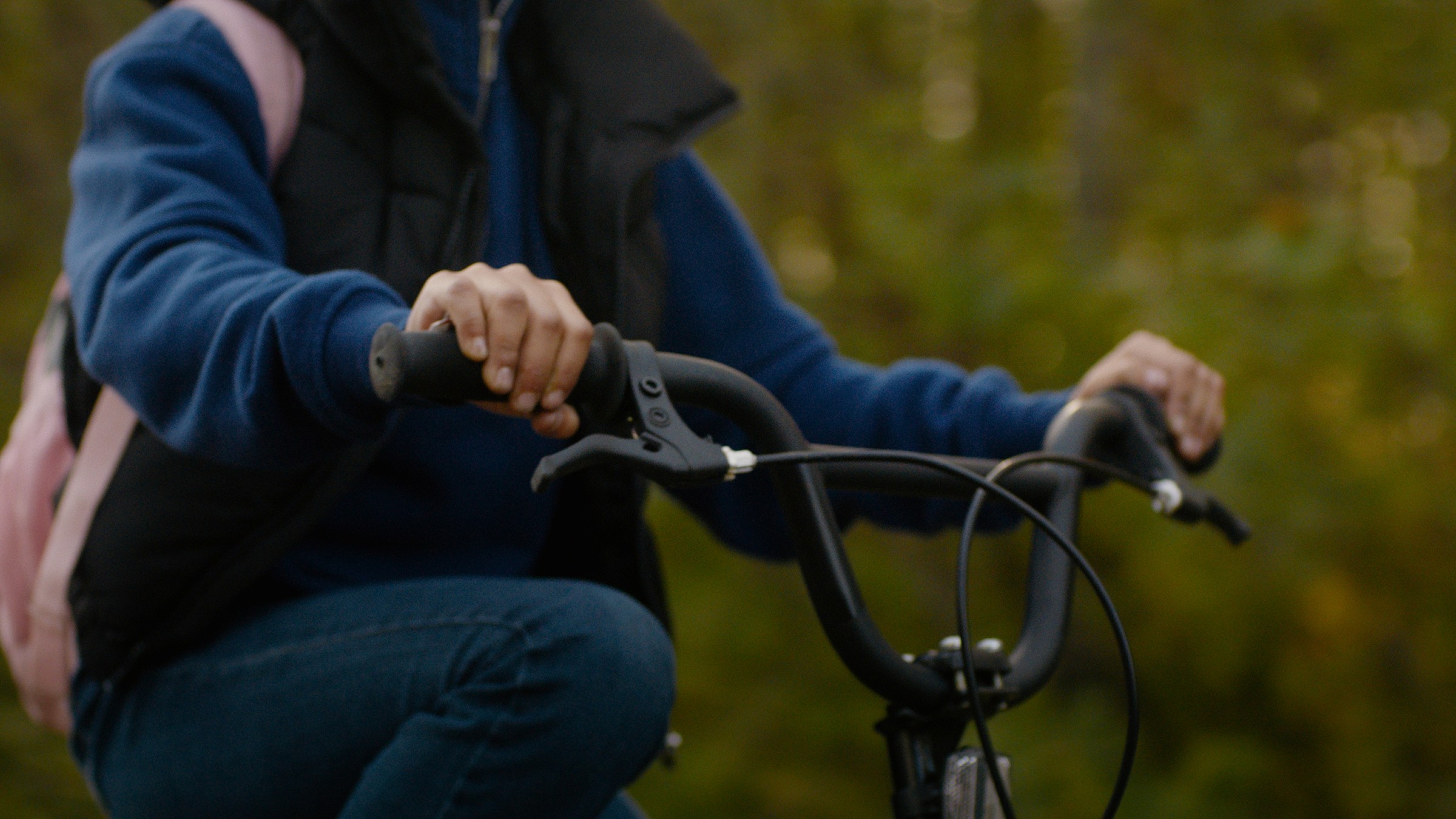 Close-up of a child's hands on bicycle handlebars — Communikit
