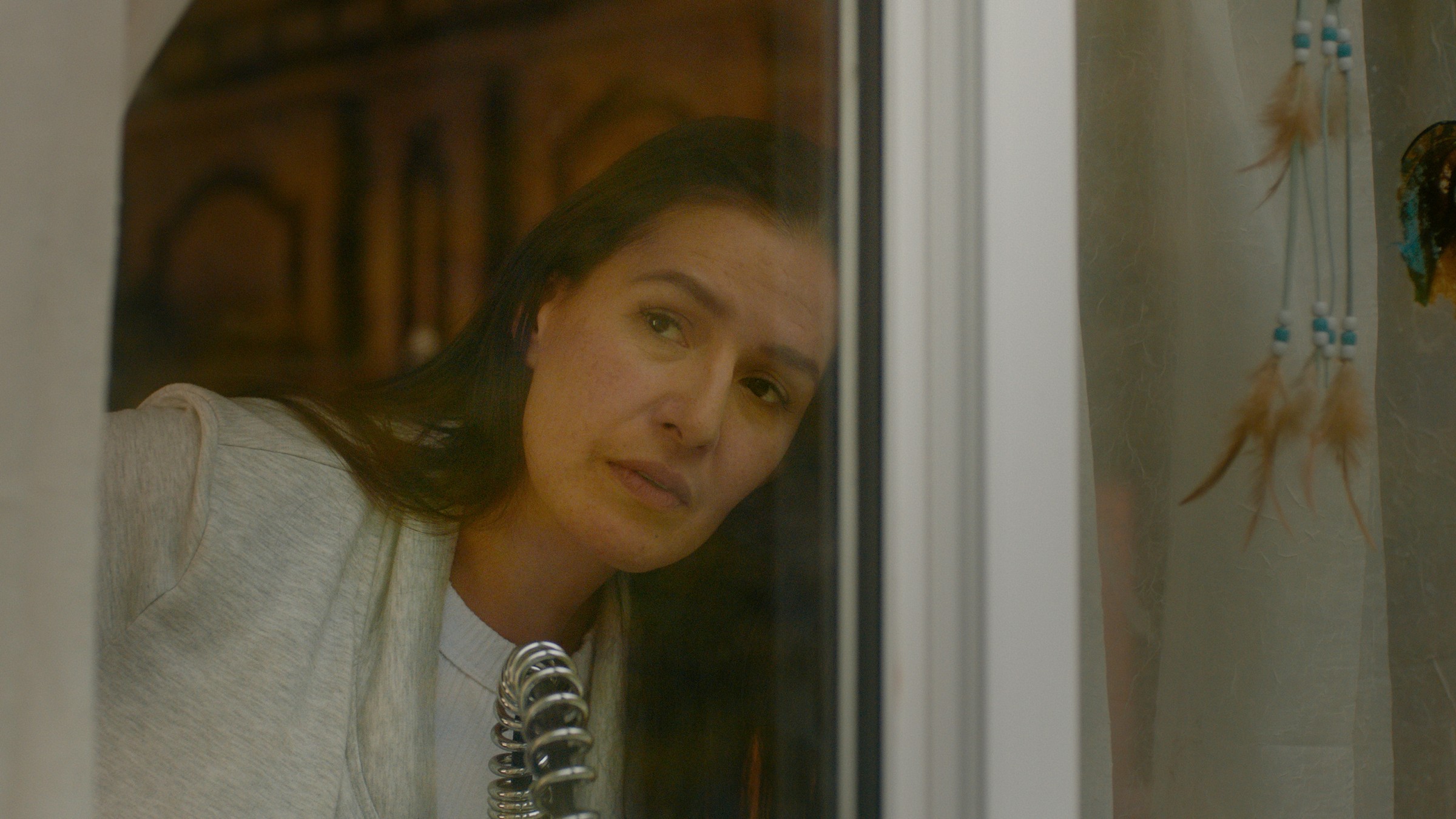A woman looks out from behind a refrigerator door in a warm kitchen — Communikit