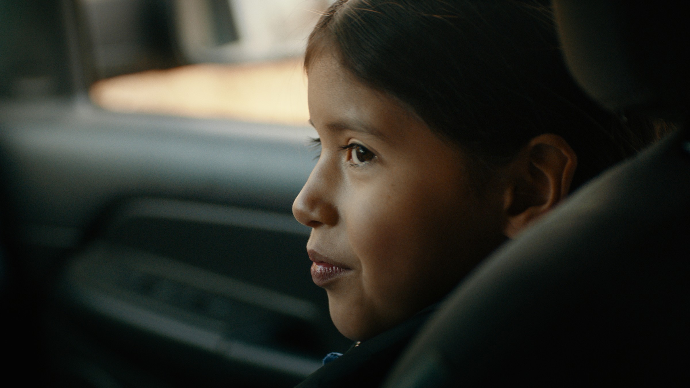 A child looks toward the front of a car from the back seat — Communikit