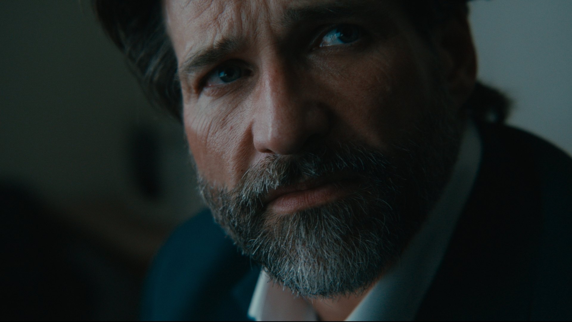 Close-up of a bearded man in cool, dim light — Crossroads
