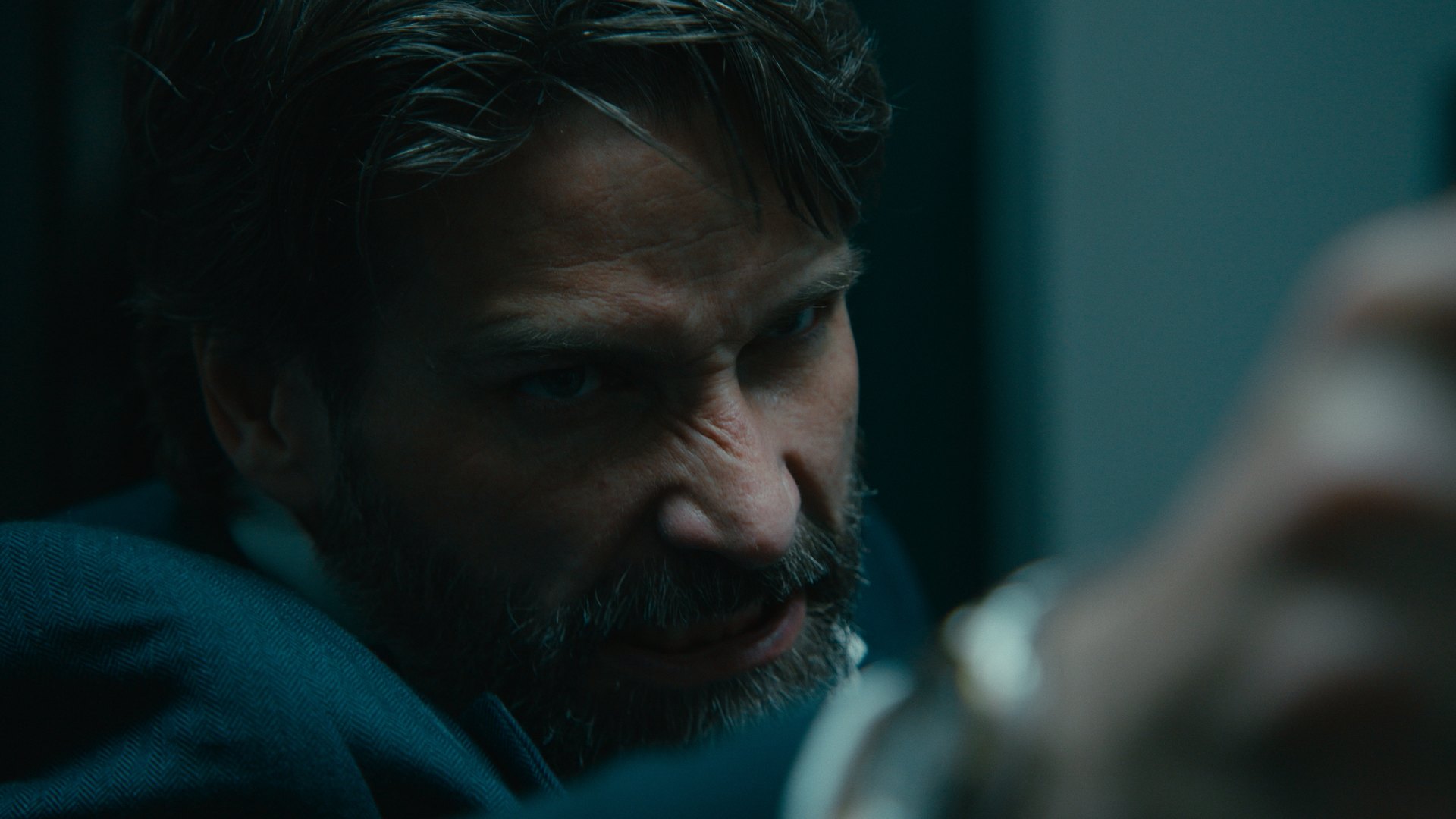 Close-up of a bearded man gesturing in cool light — Crossroads