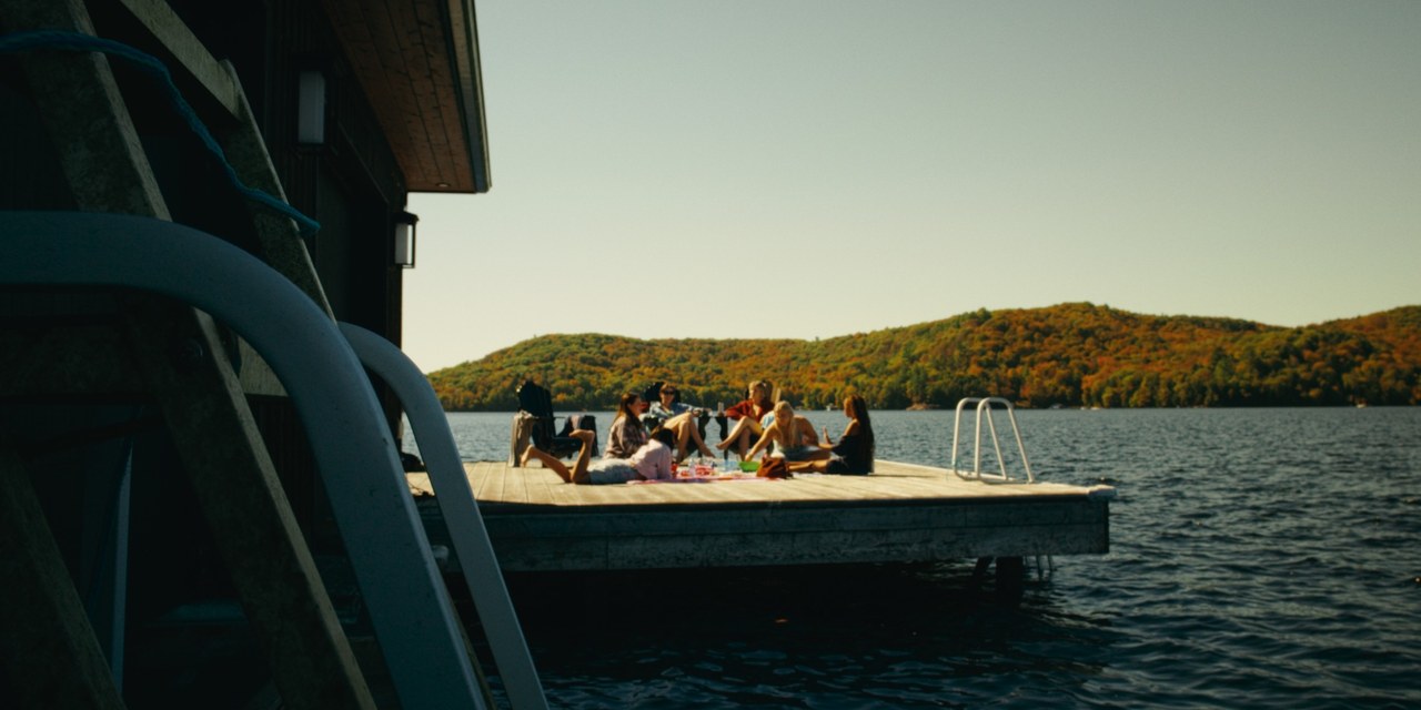 Friends gather on a sunlit dock beside a lake — Girls Weekend