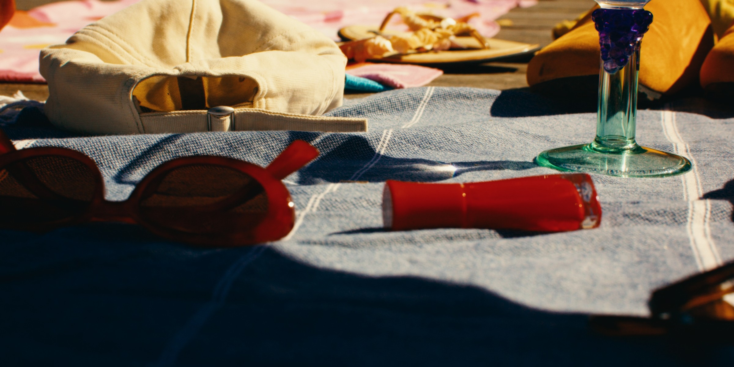 Picnic food and colorful dishes spread across a towel on a dock — Girls Weekend