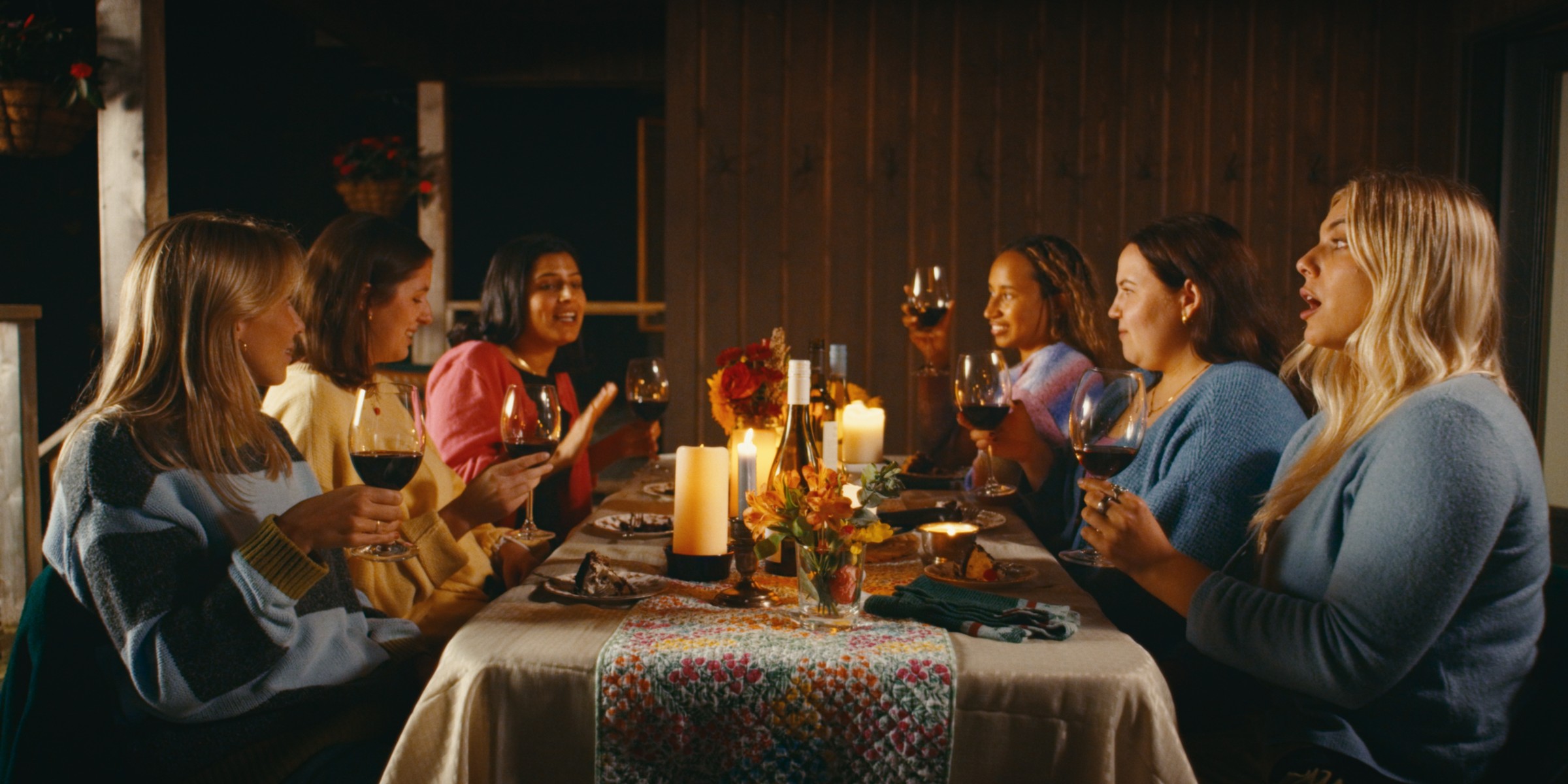 A group of friends shares a candlelit meal — Girls Weekend