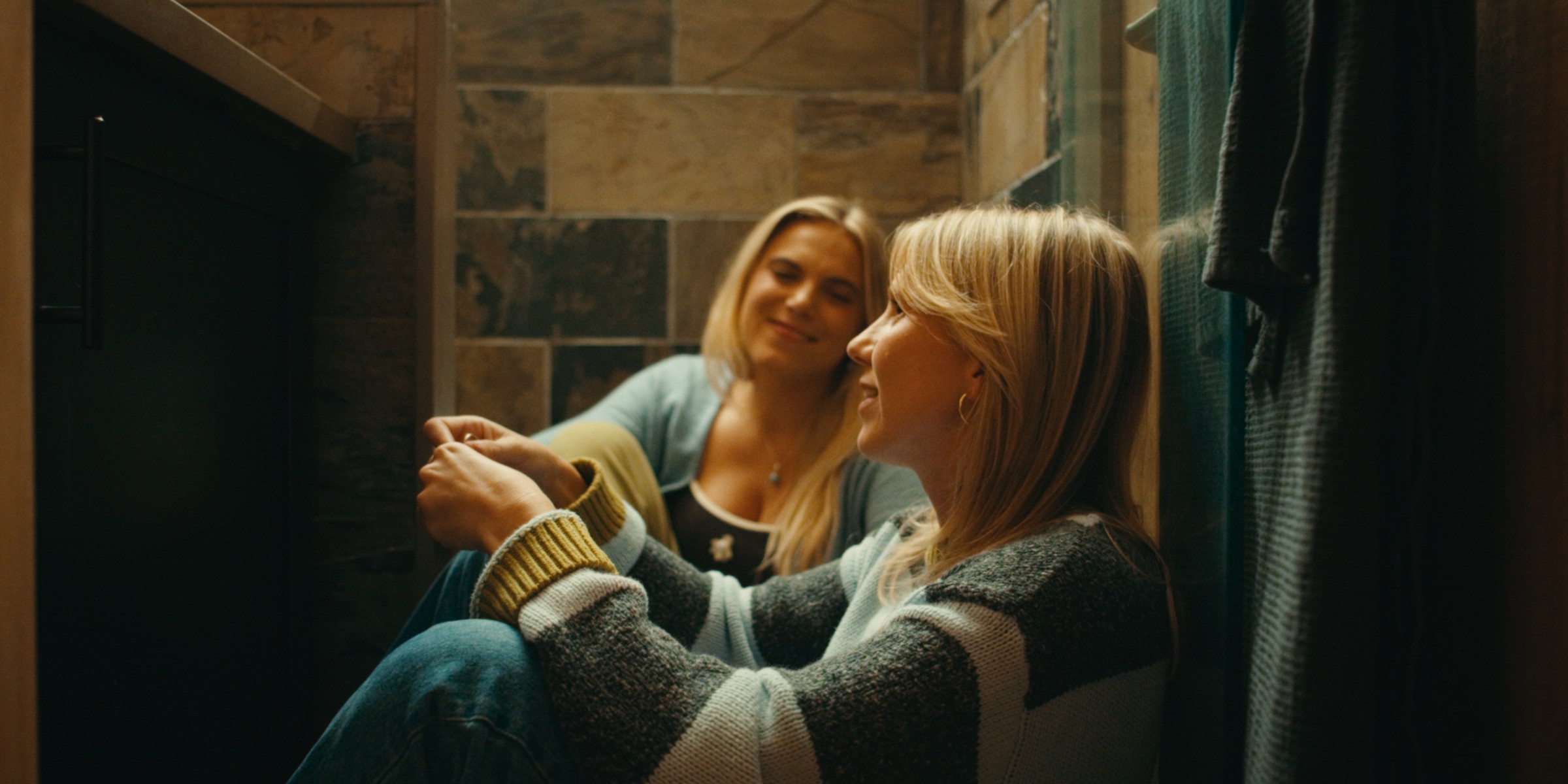 Two women relax together beside a stone fireplace — Girls Weekend