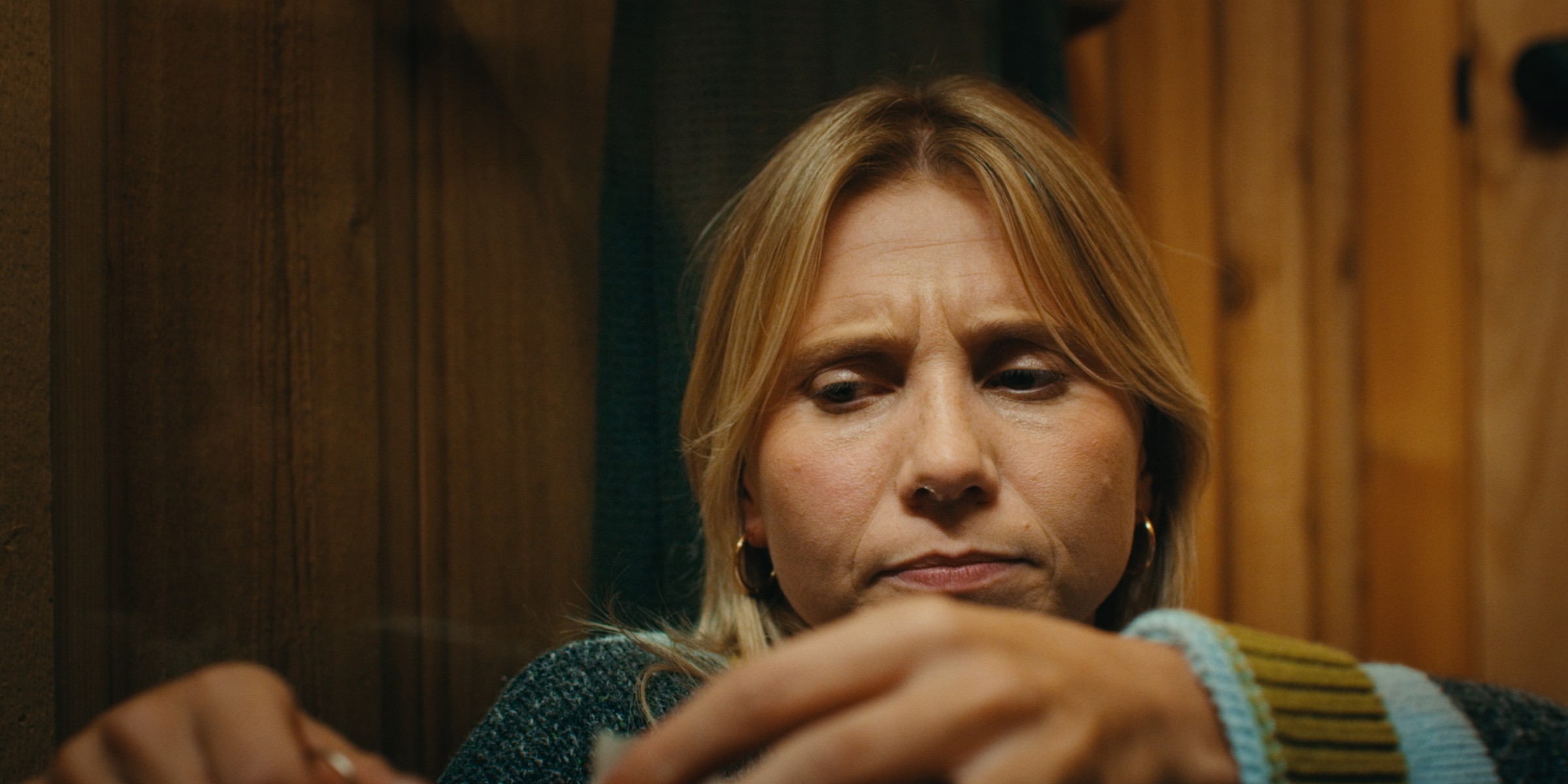 A woman rests her chin on folded hands in a cabin — Girls Weekend