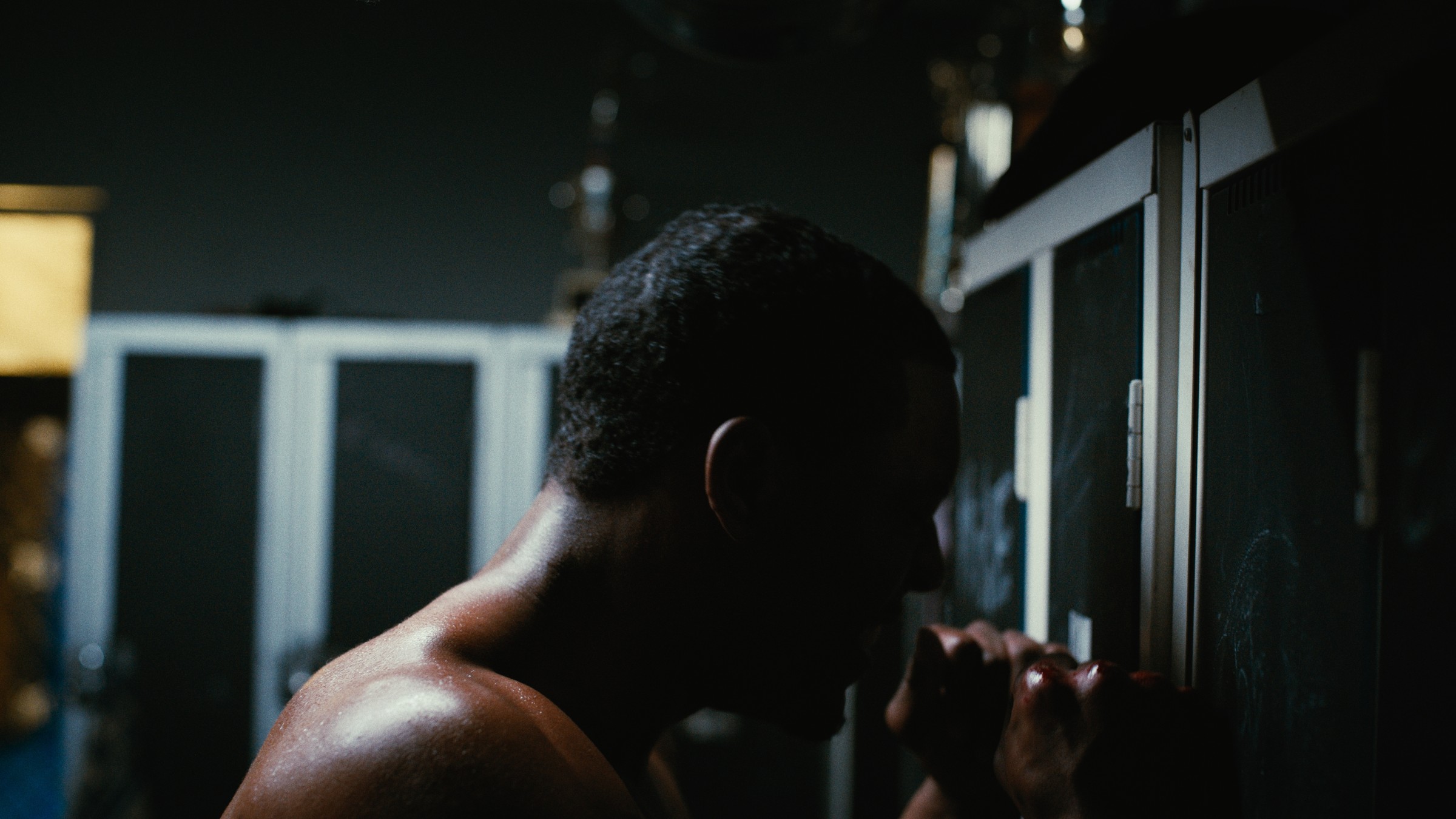 A boxer leans against a chain-link cage — Kinetic