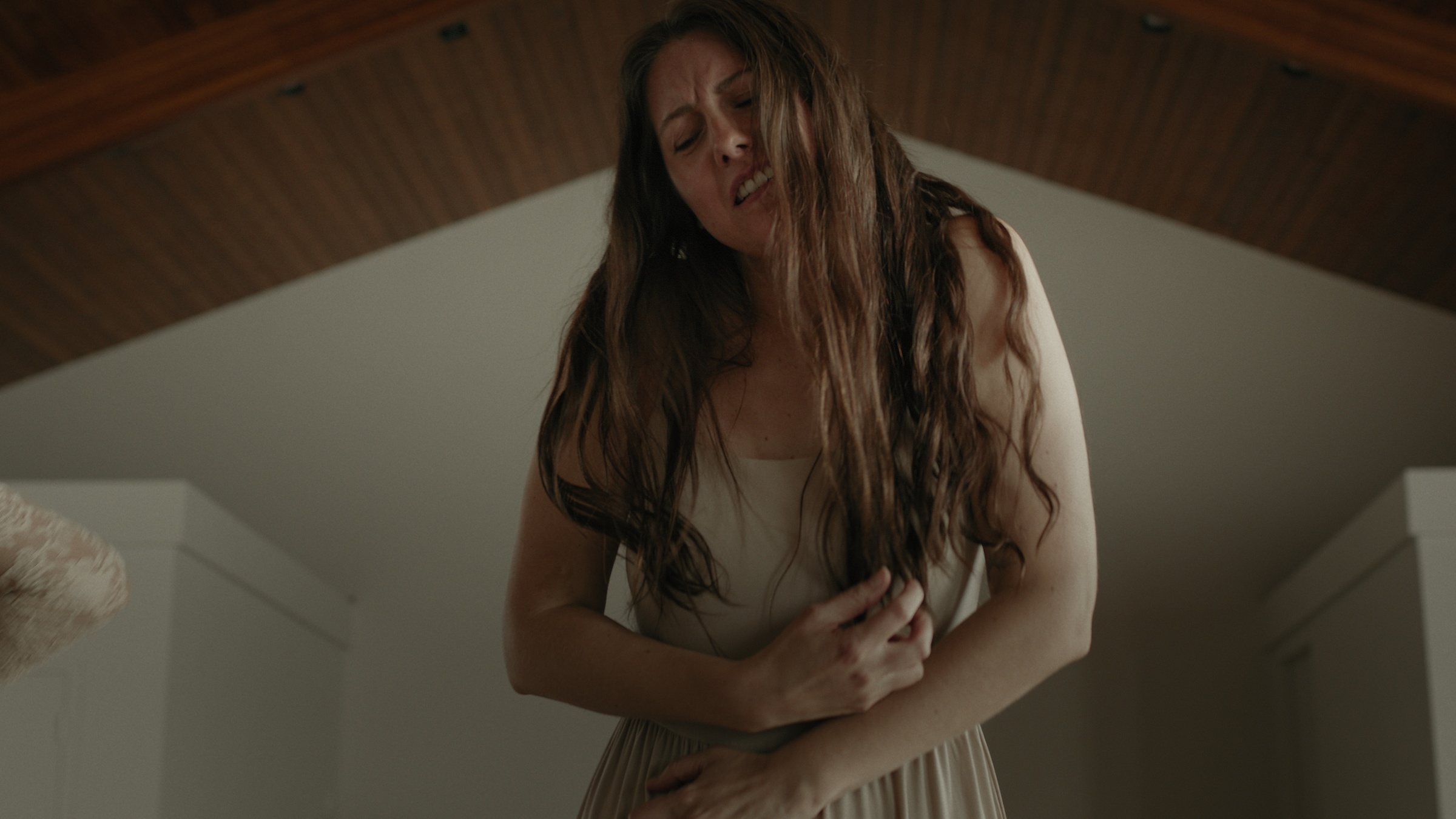 A woman leans forward beneath a wooden ceiling — Let Go