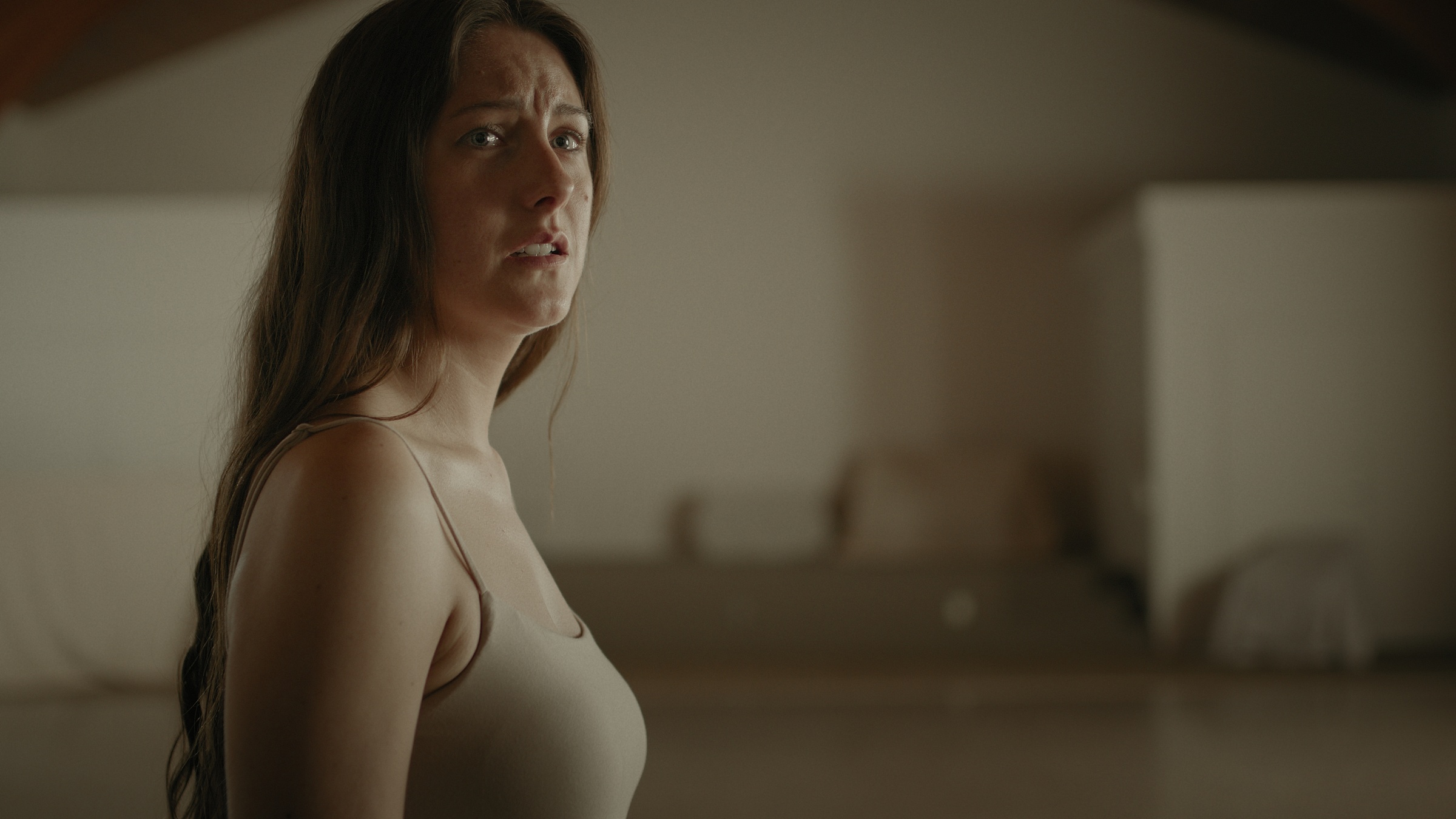 A woman turns toward the camera in soft green-toned light — Let Go