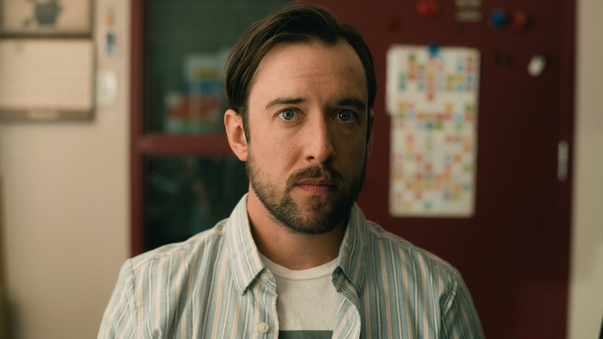 A bearded man looks ahead in a classroom — Little Fangs