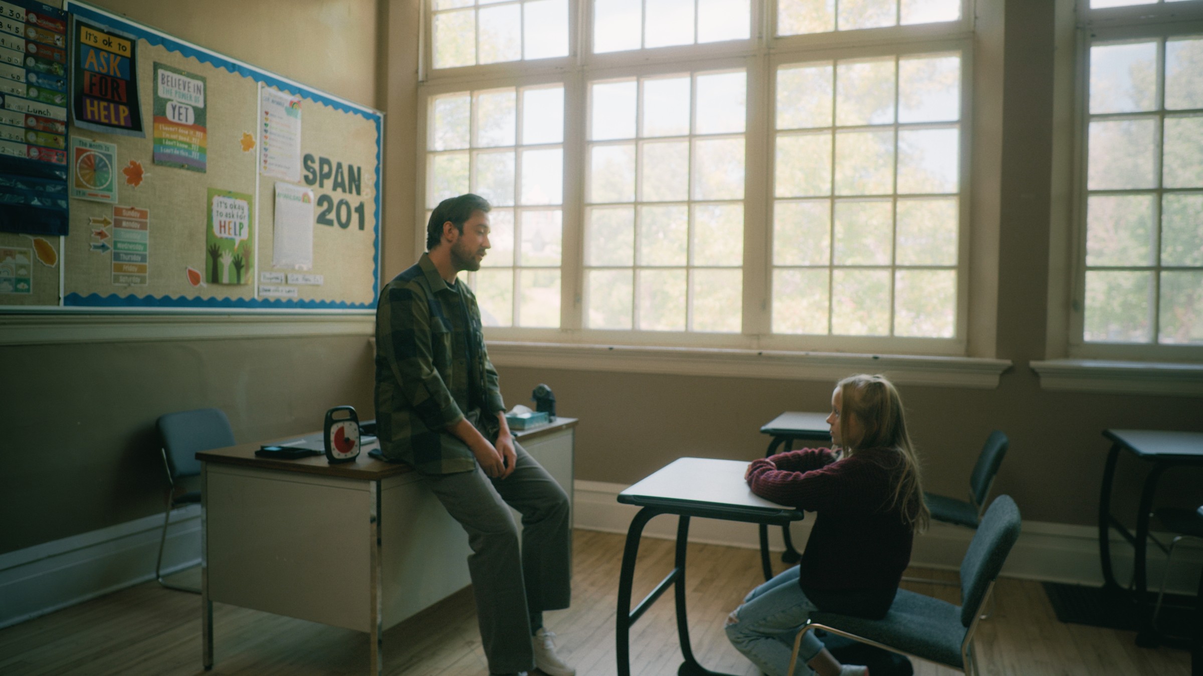 A man and a child talk beside classroom desks — Little Fangs