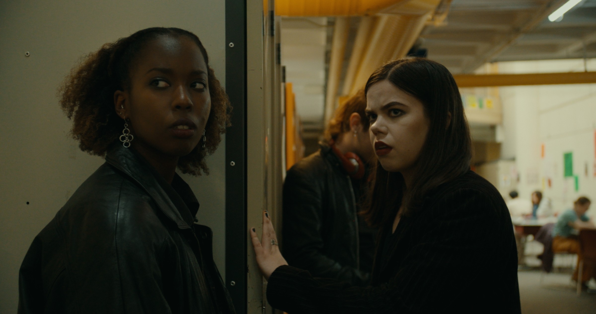 Two women look into a dim corridor — Nemesis