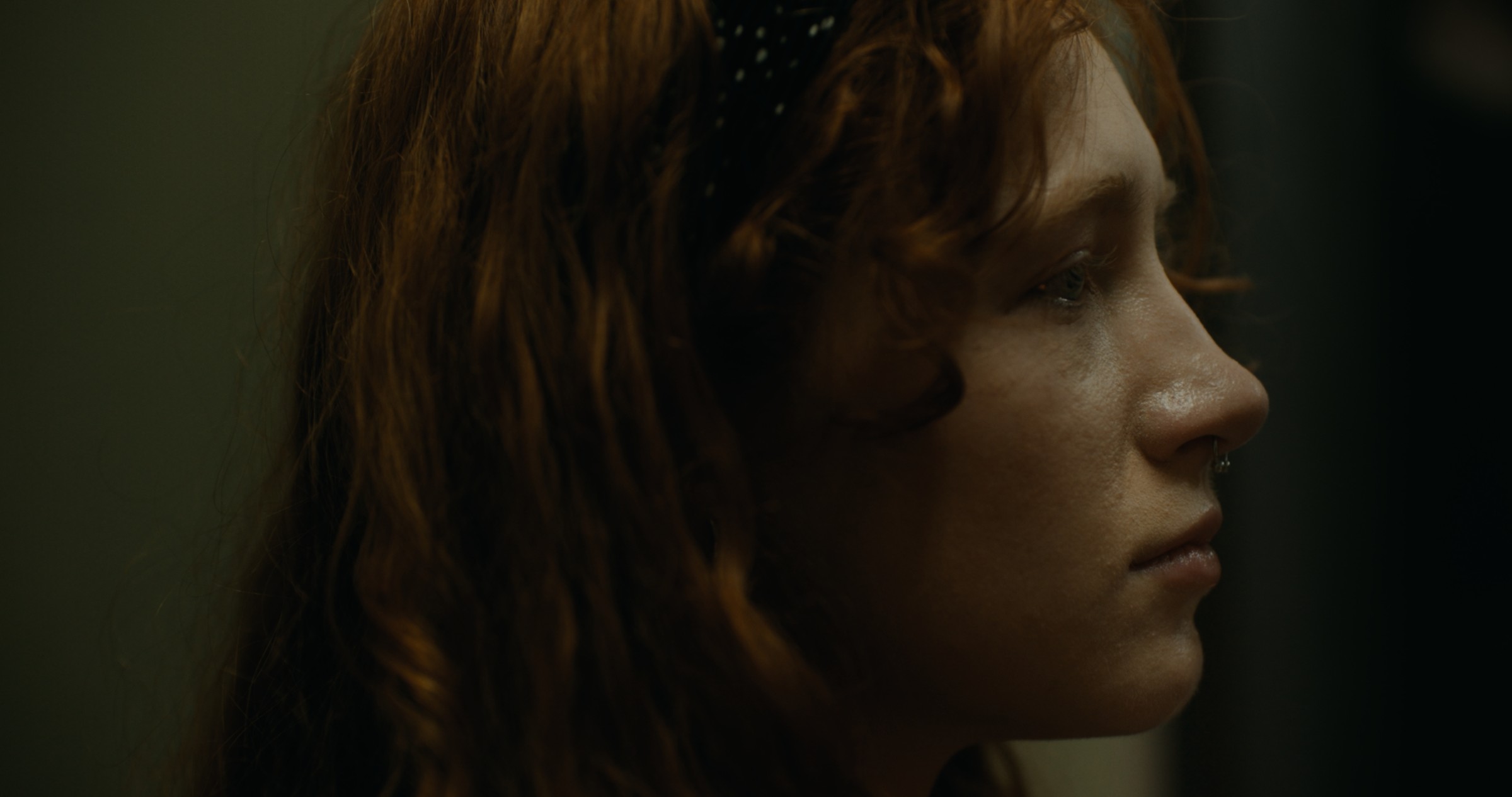 Close-up of a woman's profile in cool interior light — Nemesis