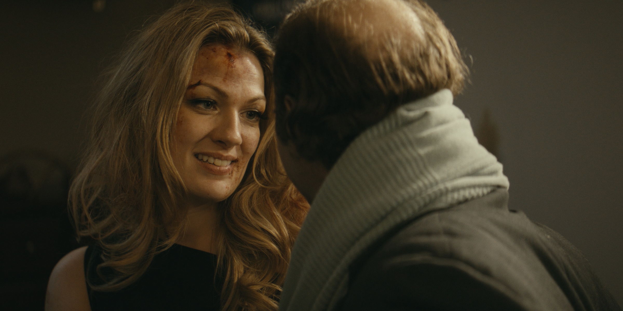 A woman smiles toward a man wearing a scarf — Trinkets