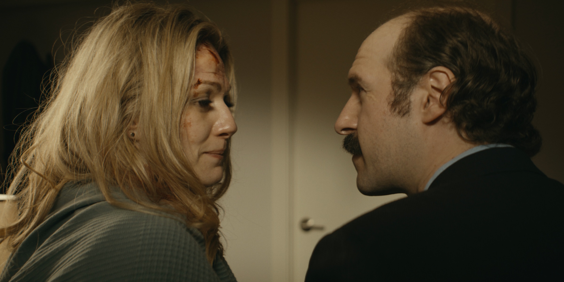A woman and a mustached man look at one another in profile — Trinkets